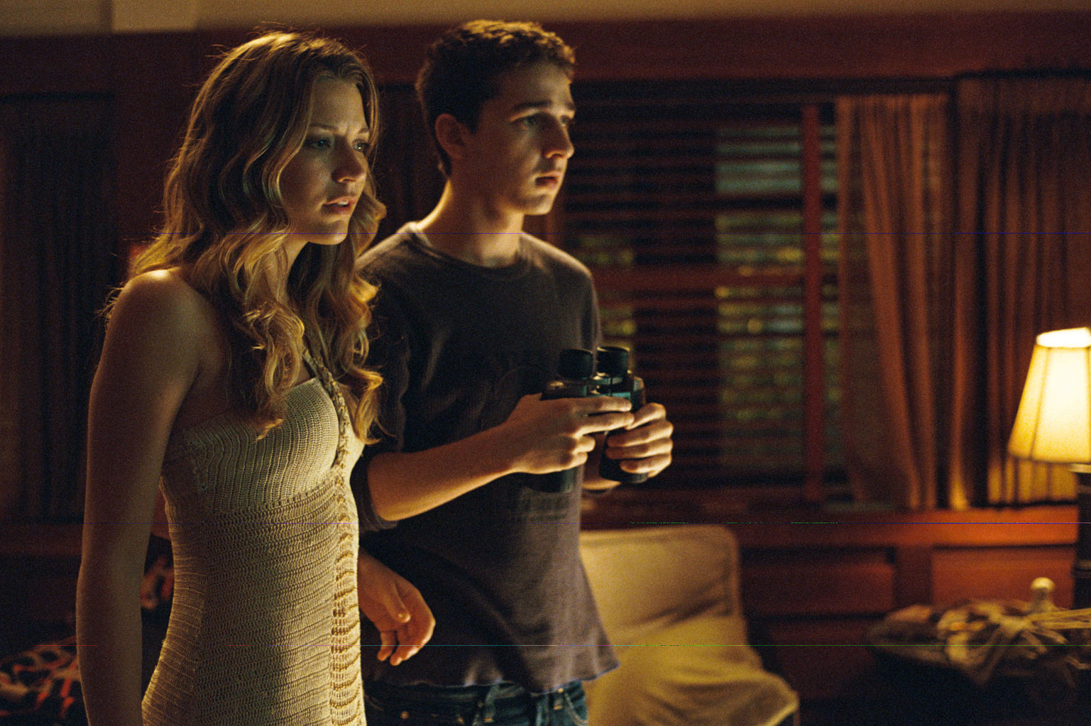 Ashley (Sarah Roemer) and Kale (Shia LaBeouf) spy on their neighbor.