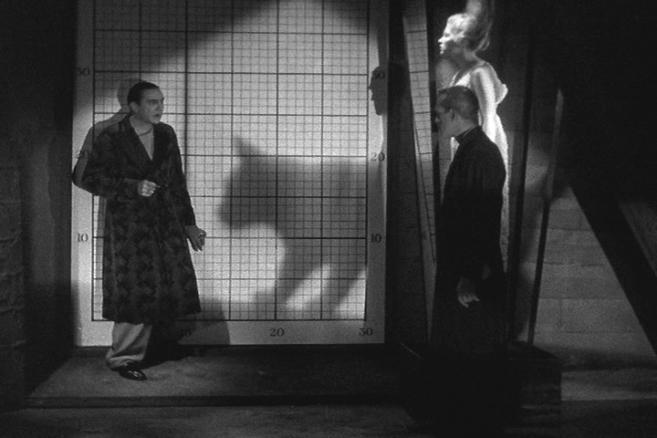 The confrontation between Belau Lugosi (left) and Boris Karloff (right) is interrupted by the shadow of the titular BLACK CAT