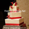 White cream wedding cake with red robbon decor